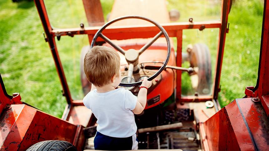 Barn i en gammel, rød traktor.